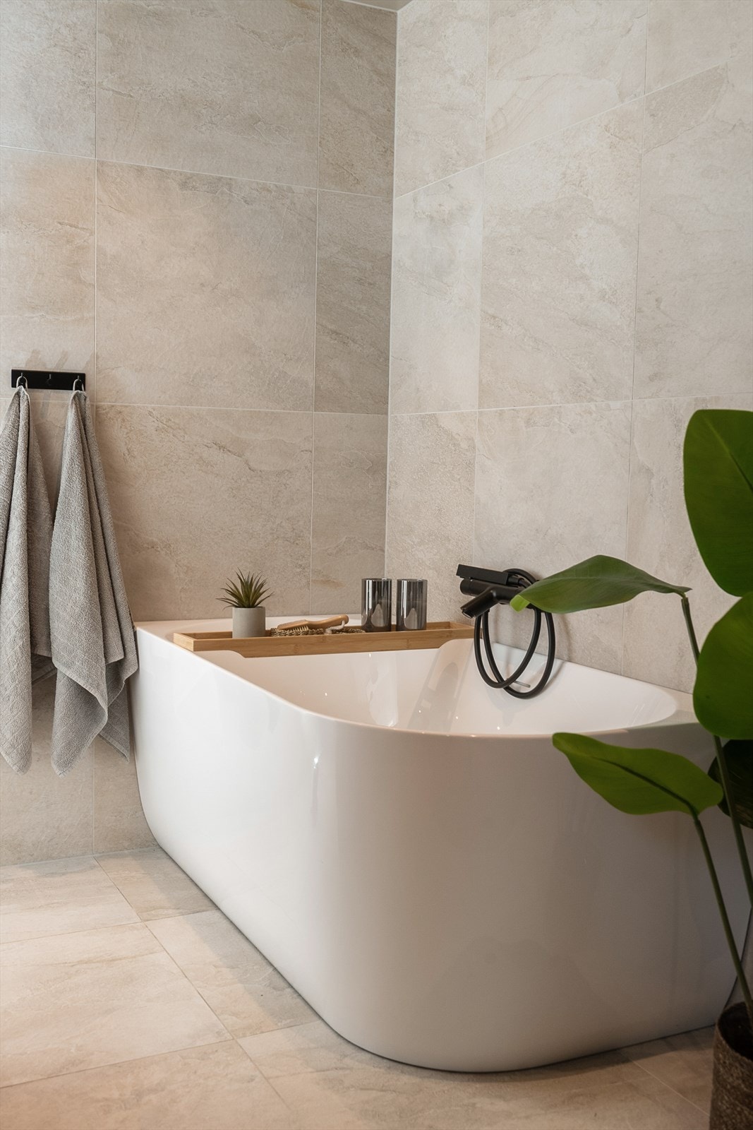 Badet er innredet med badekar, vegghengt WC og rolige me oppbevaringsplass. Galleribilde