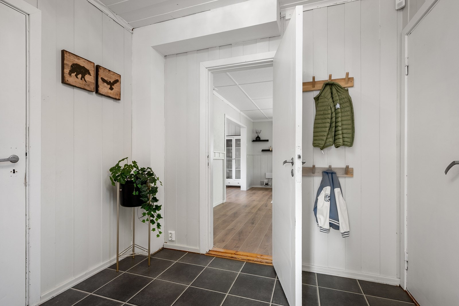 Det er dør direkte inn i stua fra gangen. I tillegg er det adkomst til kjøkkenet og ned i kjeller. Trapp opp til 2. etasje. Galleribilde
