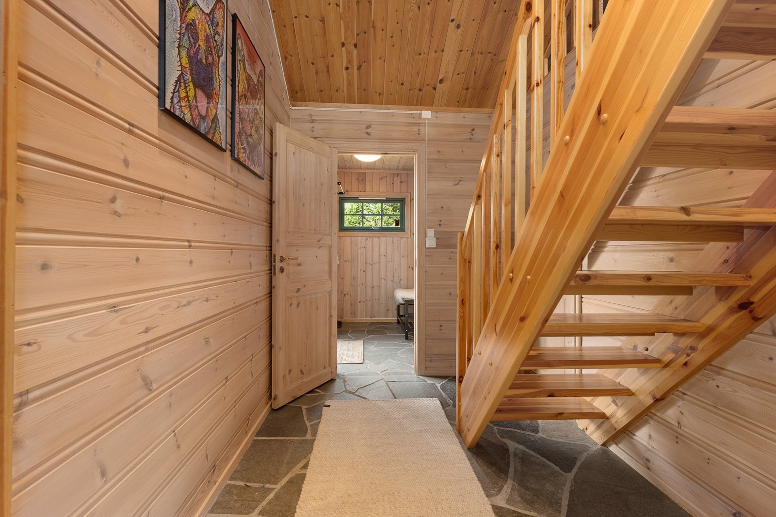 Skiferfliser med varmekabler i begge gangene. Fra den innerste gangen er det trapp opp til hemsen. Galleribilde