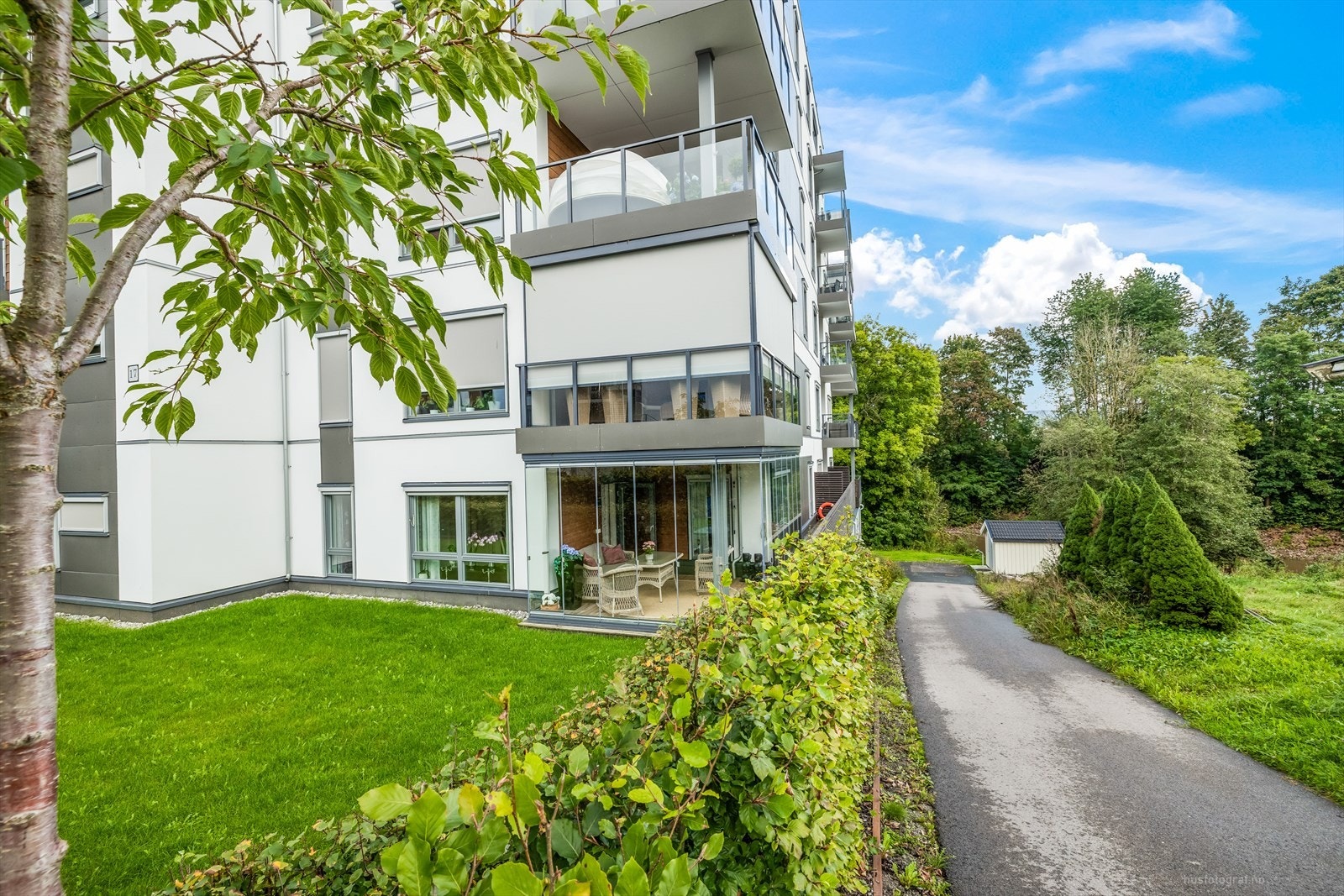 Det er gangstier, parkeringsplasser og grøntanlegg rundt leiligheten. Galleribilde