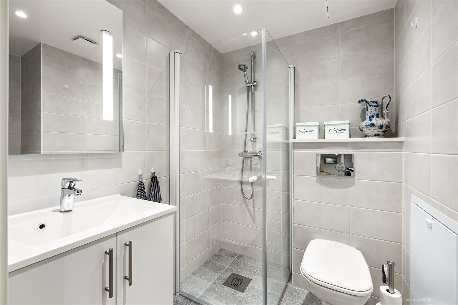 Veggene og gulvet har fliser. Malt takflate med downlights. Badet har elektriske varmekabler. Galleribilde