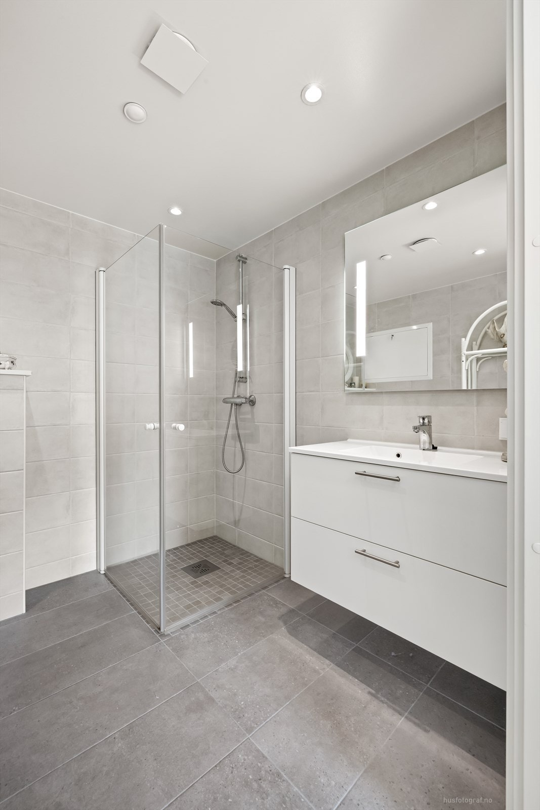 Det er speil med lys over den nedfelte servanten med skuffer under. Galleribilde