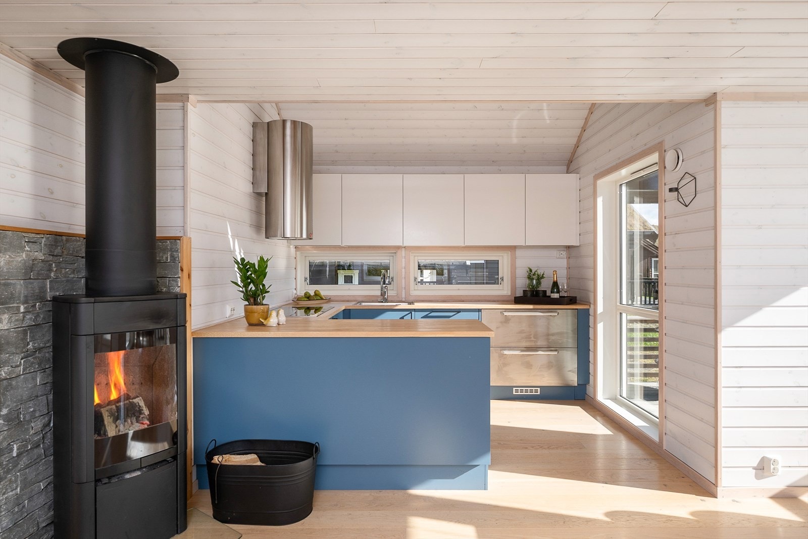 Moderne og stram innredning på kjøkkenet. Tofarget med over-og underslag for oppbevaring. Galleribilde