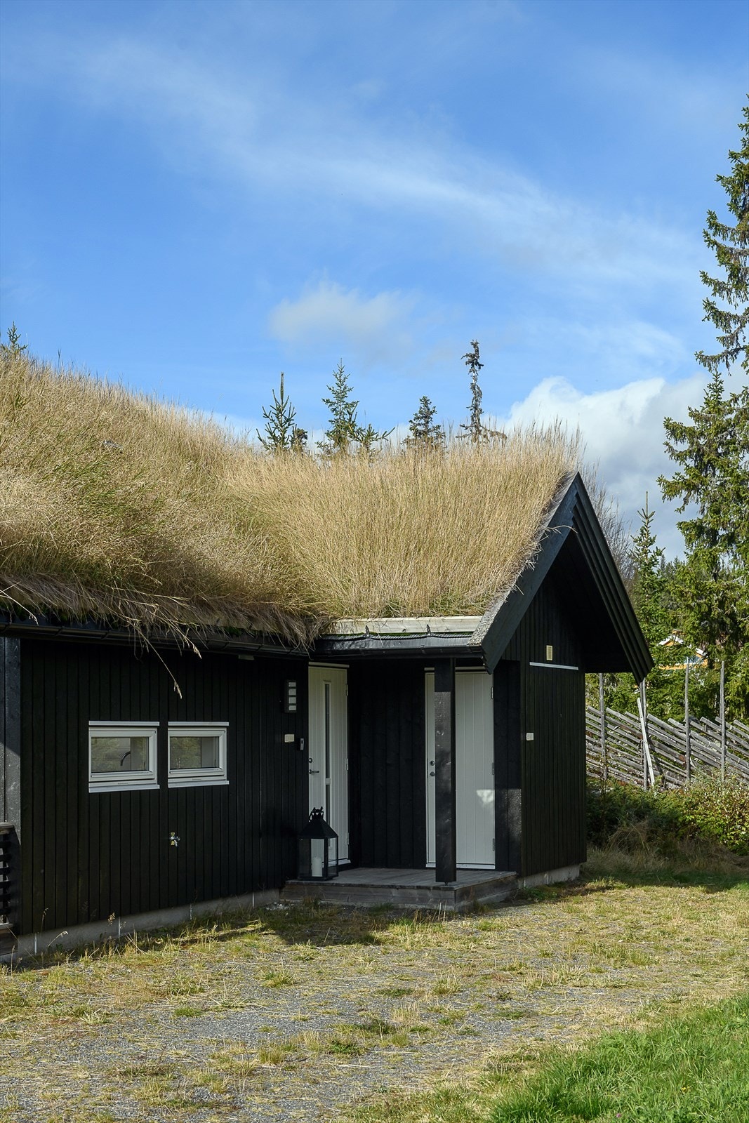 Det er et lite overbygg over inngangspartiet. Inngang til bod vis a vis inngangsdøra. Galleribilde