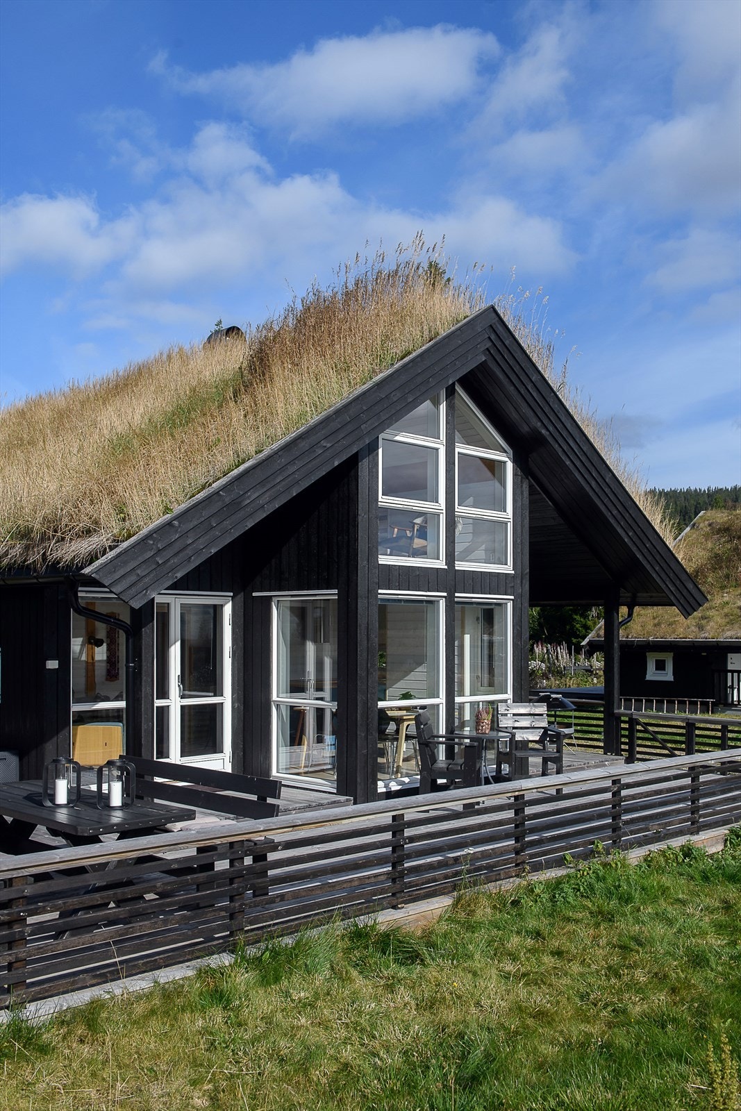 En fin kombinasjon av tradisjonelt og moderne. Stramme former og stor vinduer i en god kombinasjon med torvtak. Galleribilde