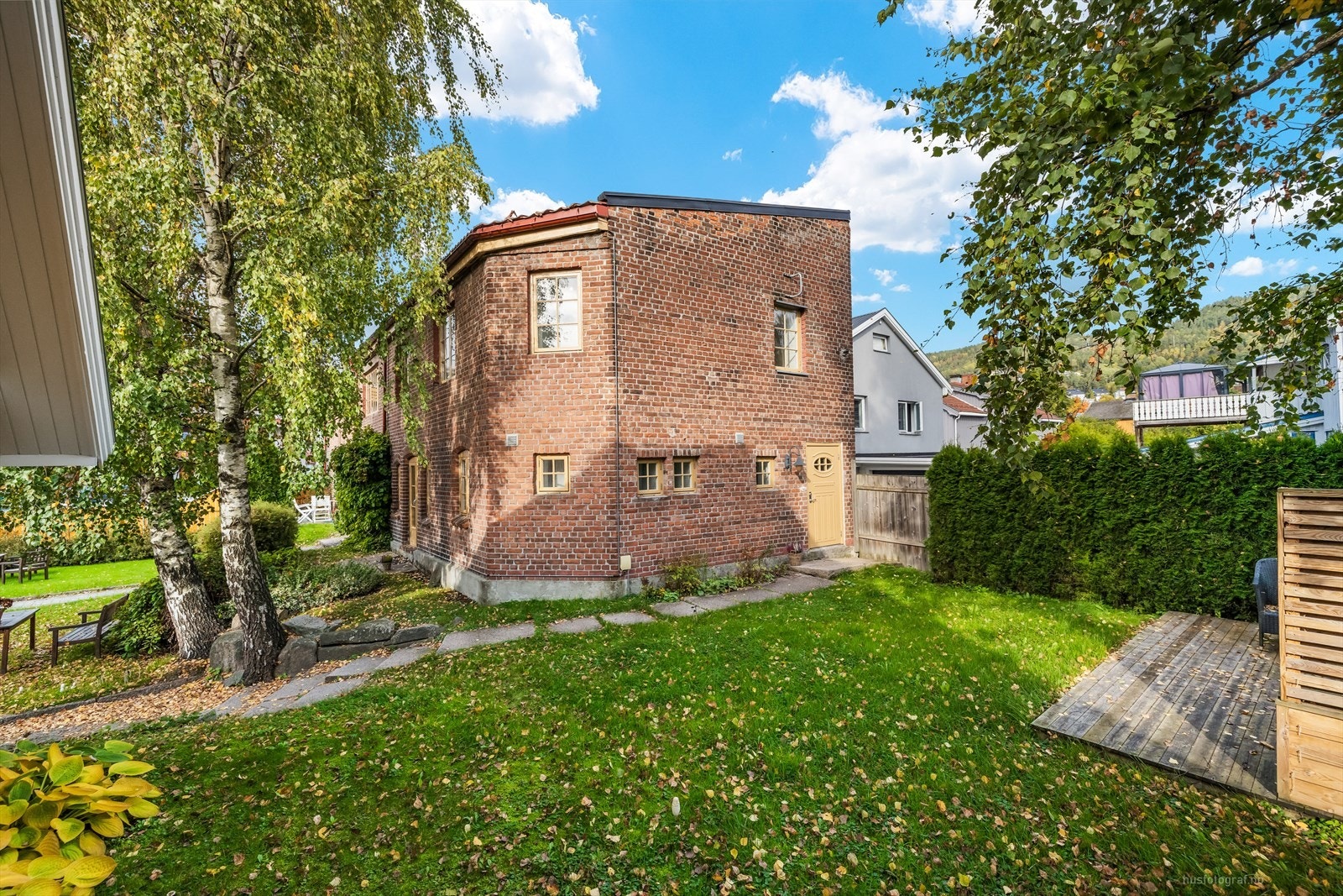 Felles uteområde er inngjerdet og pent opparbeidet med plen og beplantning. Galleribilde