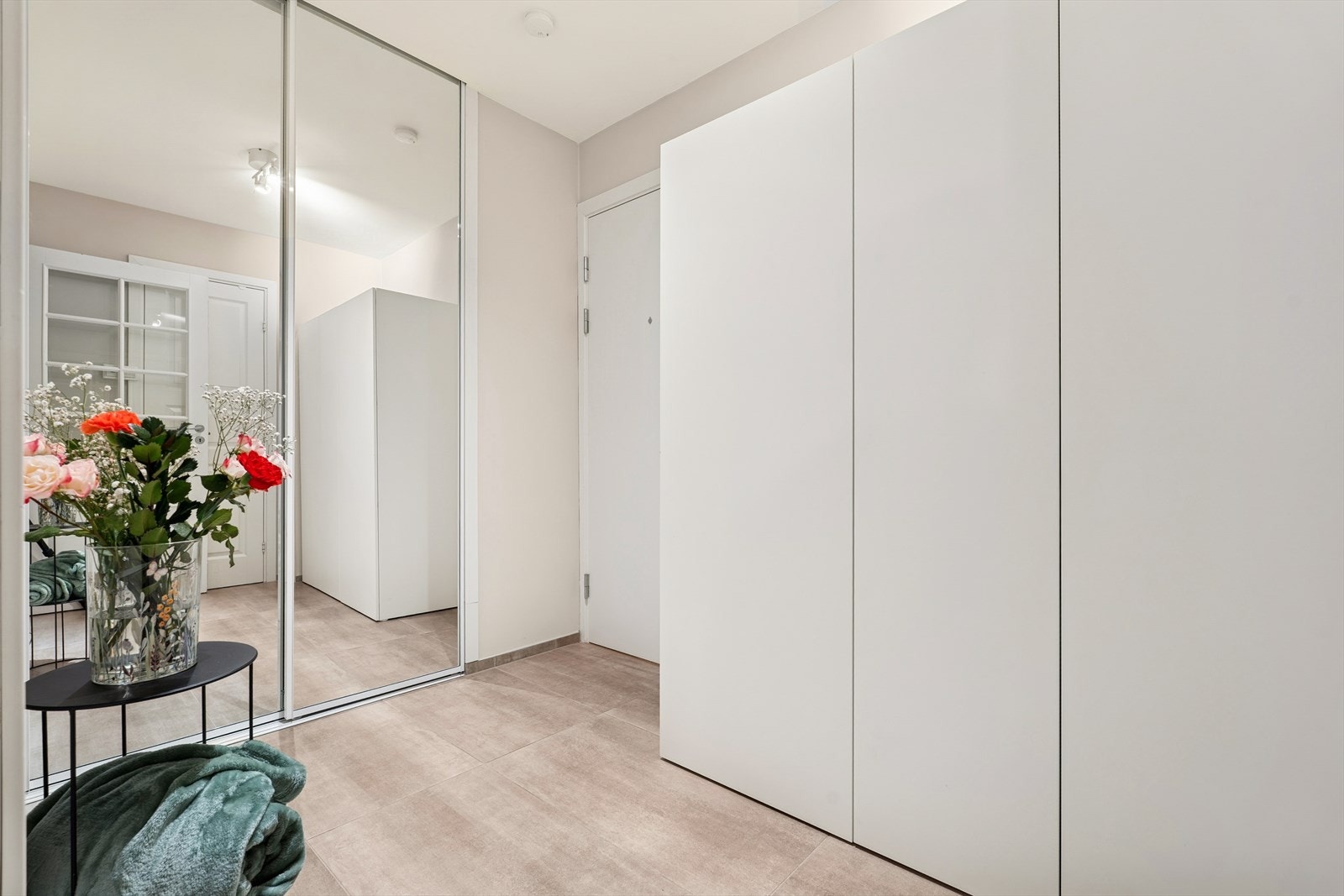 Velkommen inn i en lys og pen entré med skyvedørsgarderobe Galleribilde