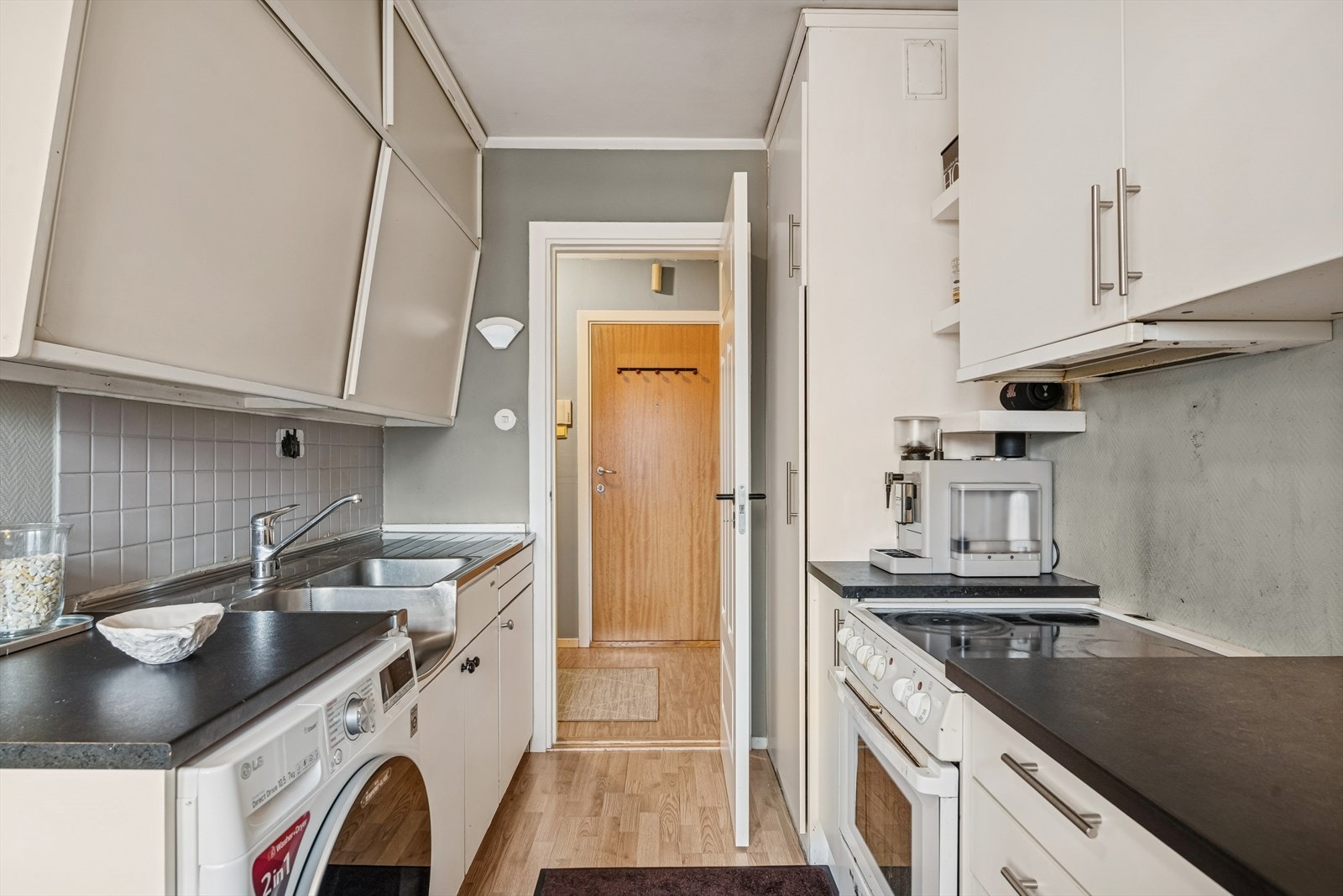 Kjøkkenet er praktisk innredet og utstyrt med komfyr og løst kjøleskap, samt en montert vaskemaskin. Galleribilde