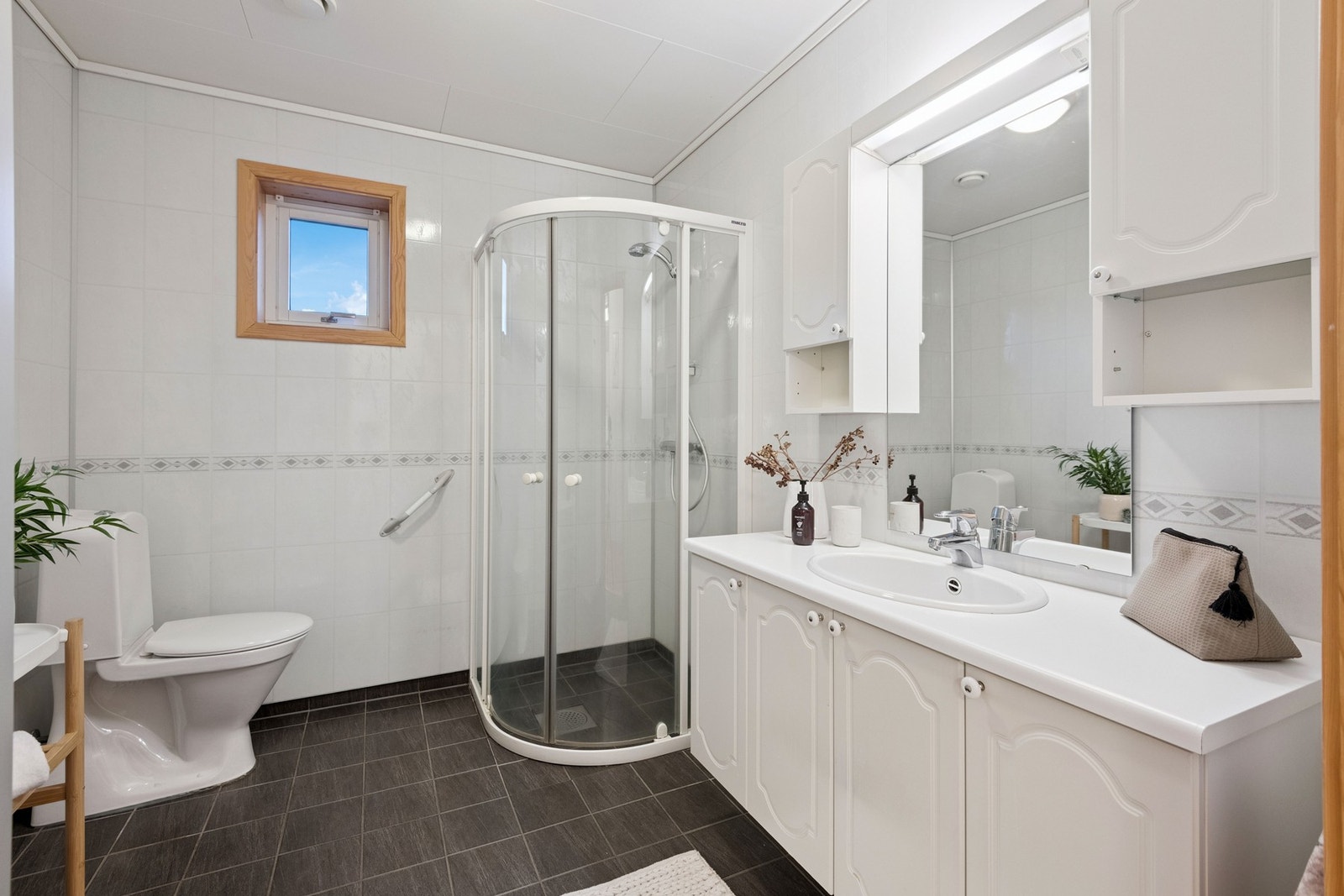 Badet har flislagt gulv og vannbåren gulvvarme. Våtromsplater på vegger. Badet ble oppusset i 2017. Galleribilde