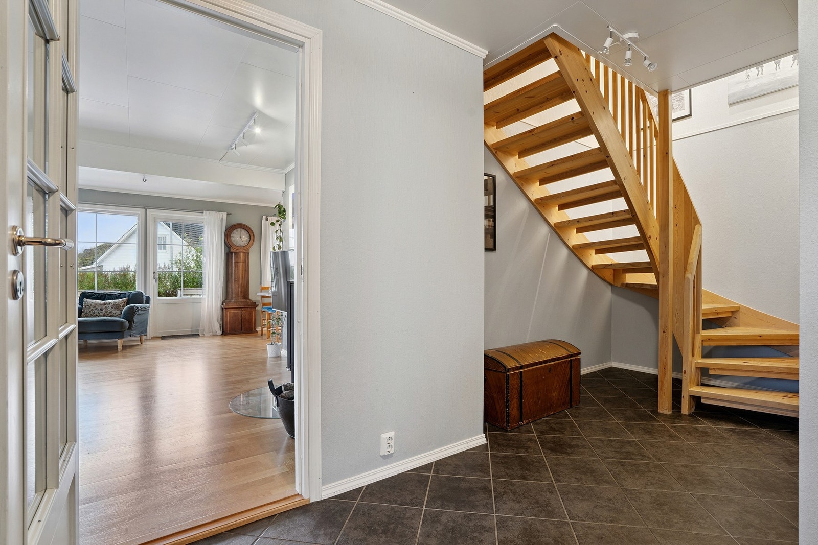 Den flislagte hallen gir adkomst til soverom, baderom, separat vaskerom, trapp til øvre plan, samt tilgang på stuen og kjøkkenet. Galleribilde