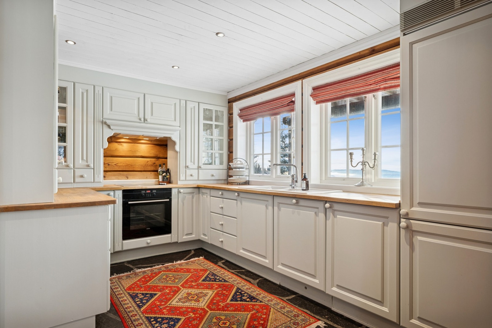 Et pent kjøkken som har godt med skap og benkeplass. Galleribilde