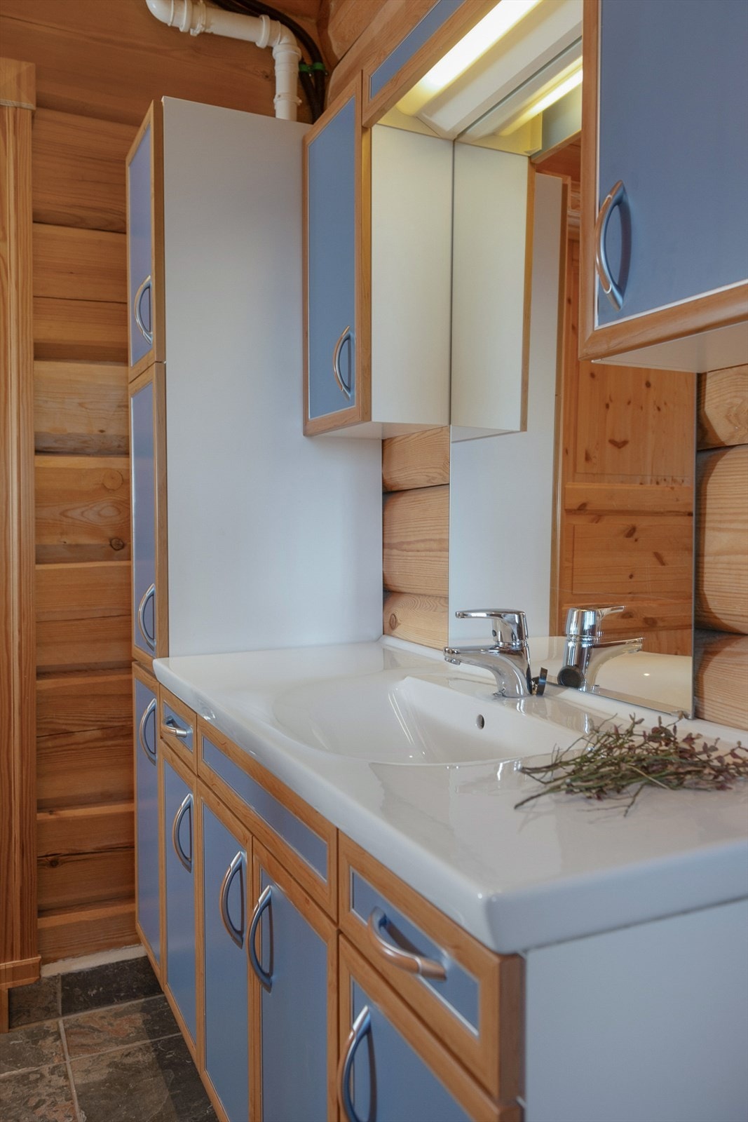 Baderommet er med fliselagte overflater på gulv, tømmer og panel på vegger. Videre er baderommet innredet med baderomsinnredning med servant, overskap, speil, toalett og dusjkabinett. Galleribilde