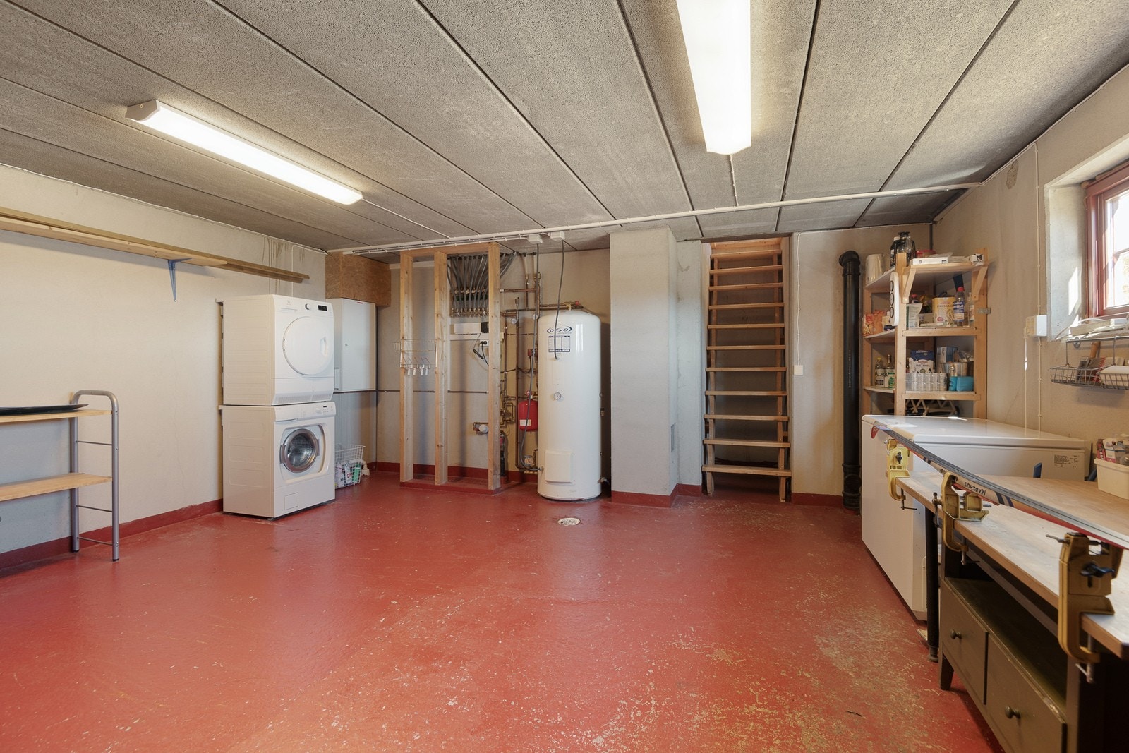 Kjelleren er av stor størrelse og har plass til både vaskemaskin, tørketrommel, ski, snowboard, pulker, kjelker, smørebord med stativ og fryseboks. Galleribilde