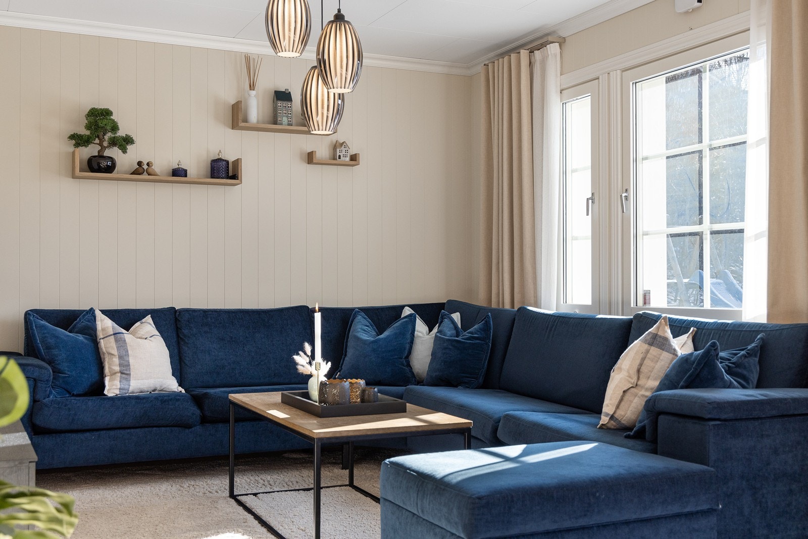 Stuen har lysbeige panelplater på veggene, glatt, hvitmalt himling og enstavs laminatgulv - trendy og harmonerende. Galleribilde