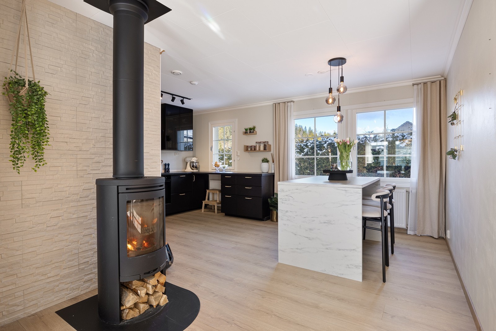 I 2023 ble kjøkkenet supplert med en stor kjøkkenøy med flere spiseplasser, dype kolonialskuffer og benkeplate i lys, marmorert laminat. Galleribilde