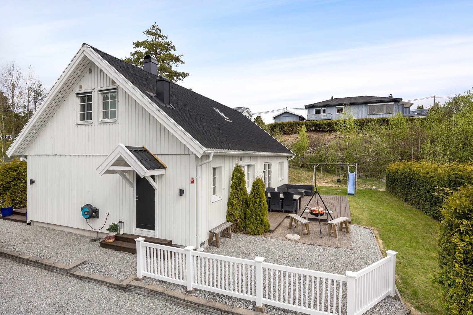 Tomten rundt boligen er pent opparbeidet i ulike soner med grus, stenbelagt, treplatting og plen. Galleribilde