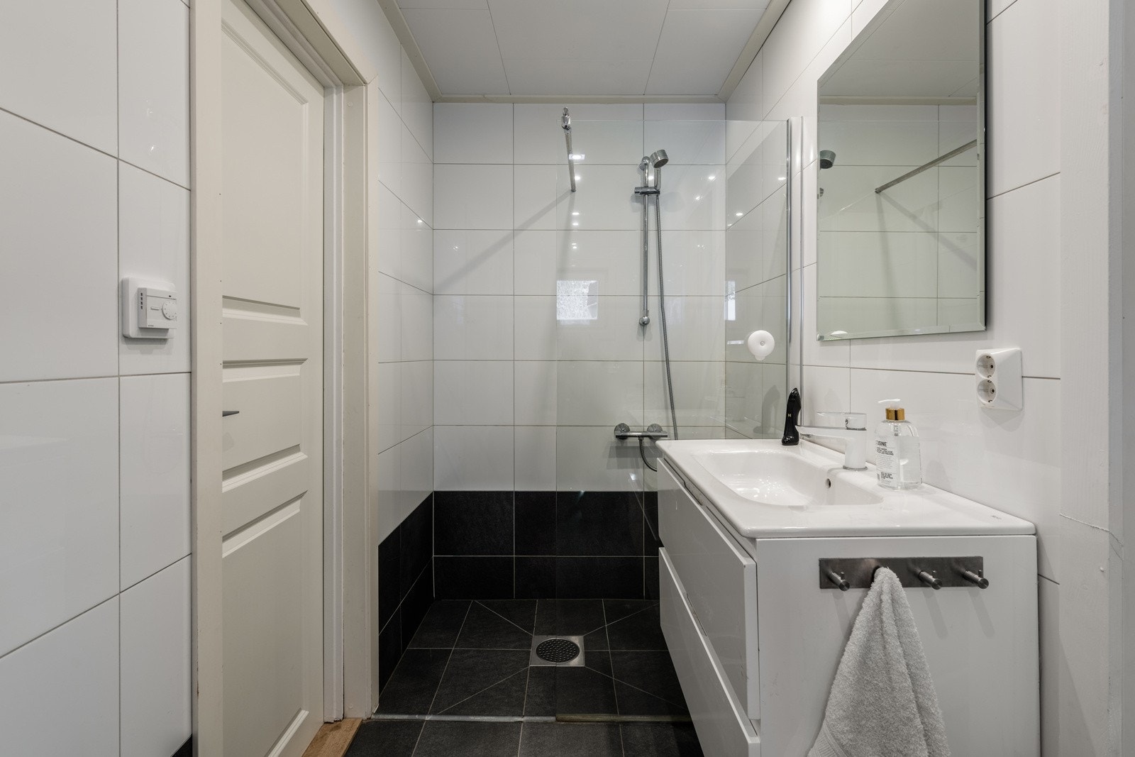 Dusjhjørnet og badromsinnredning med speil over Galleribilde