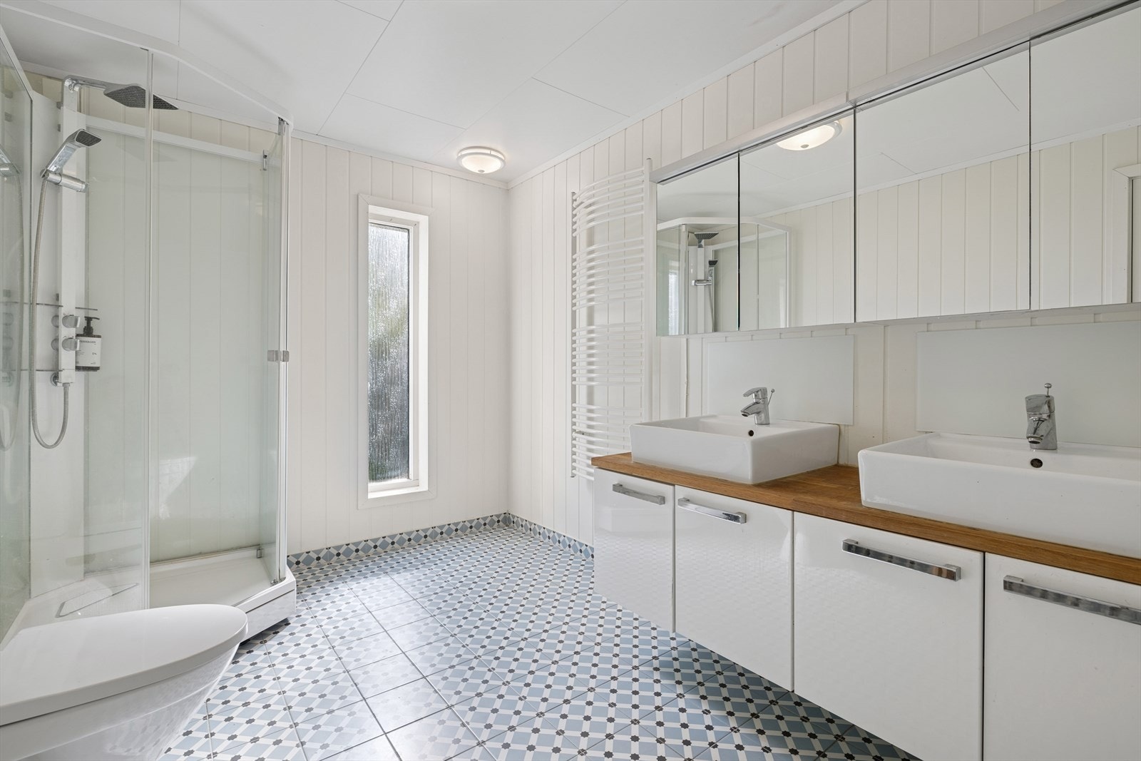 I enden av entreen kommer vi til badet i 1.etasje. Et stort bad med to servanter. Her er det varmekabler i gulvet. Galleribilde