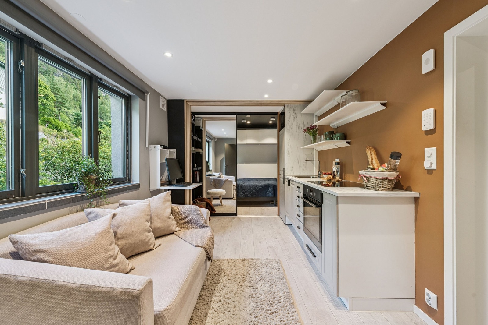 Lys stue med store vinduer og åpen kjøkkenløsning, plass til både kos og måltider. Galleribilde