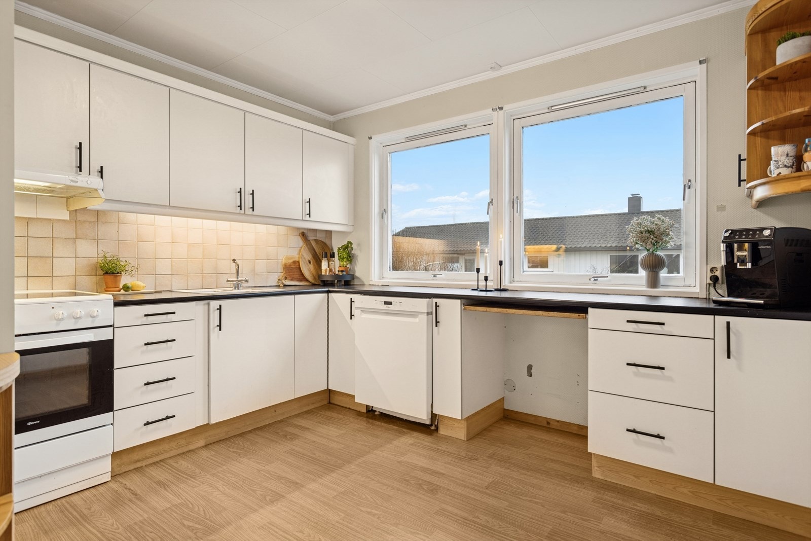 Lys kjøkkeninnredning med folierte skrog med slette fronter og laminert benkeplate. Galleribilde