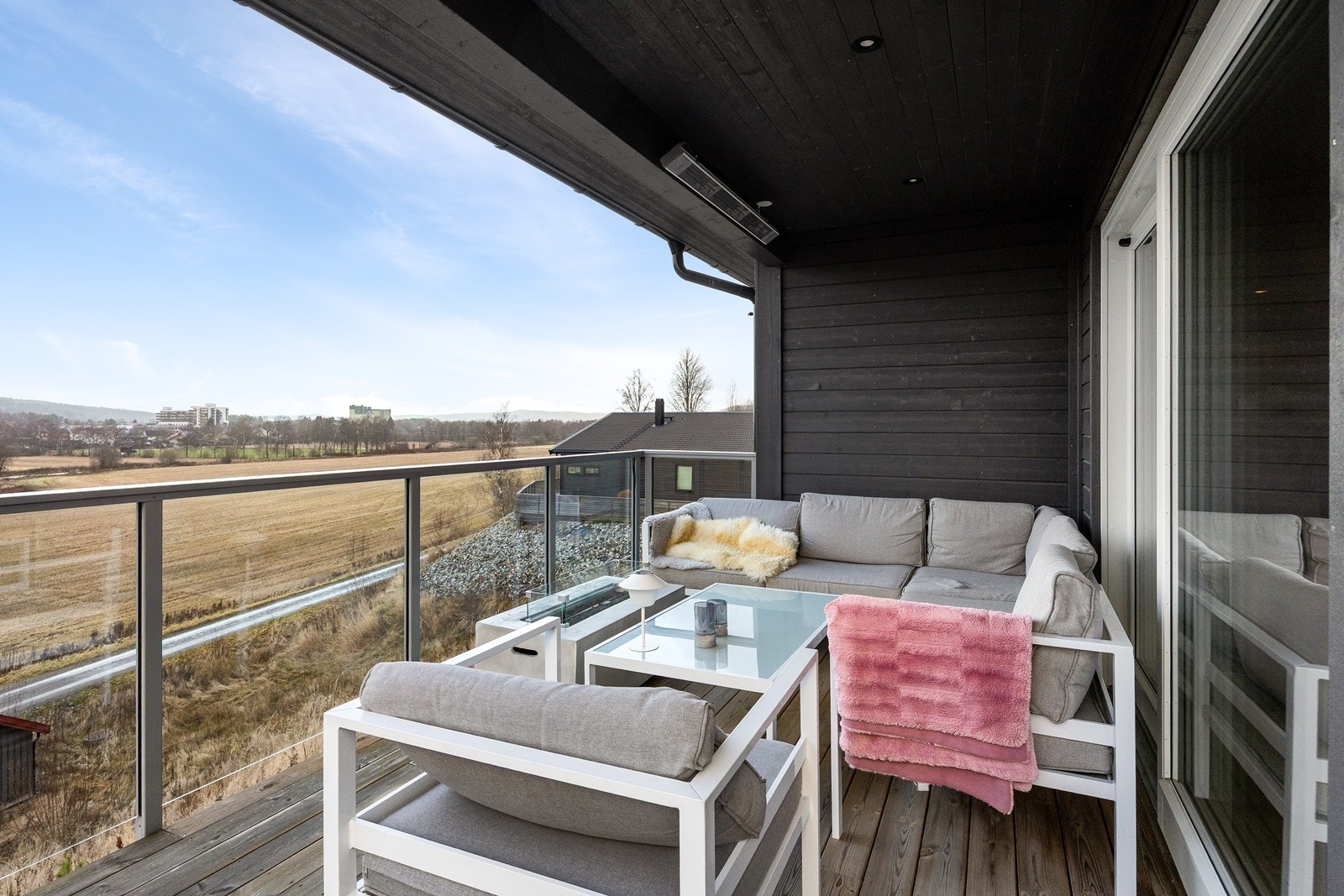 Sommerdagene tilbringes også på en delvis overbygd veranda i forlengelse av hovedstuen. Verandaen har utestikk, downlights og et areal på ca. 14 kvm. Glassflater langs rekkverket ivaretar den naturskjønne utsikten. Galleribilde