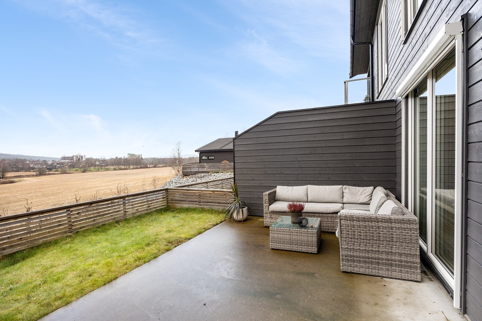 Terrassen er av betong, med adkomst fra både stuen og soverommet i underetasjen. Det er levegg mot naboen. Galleribilde