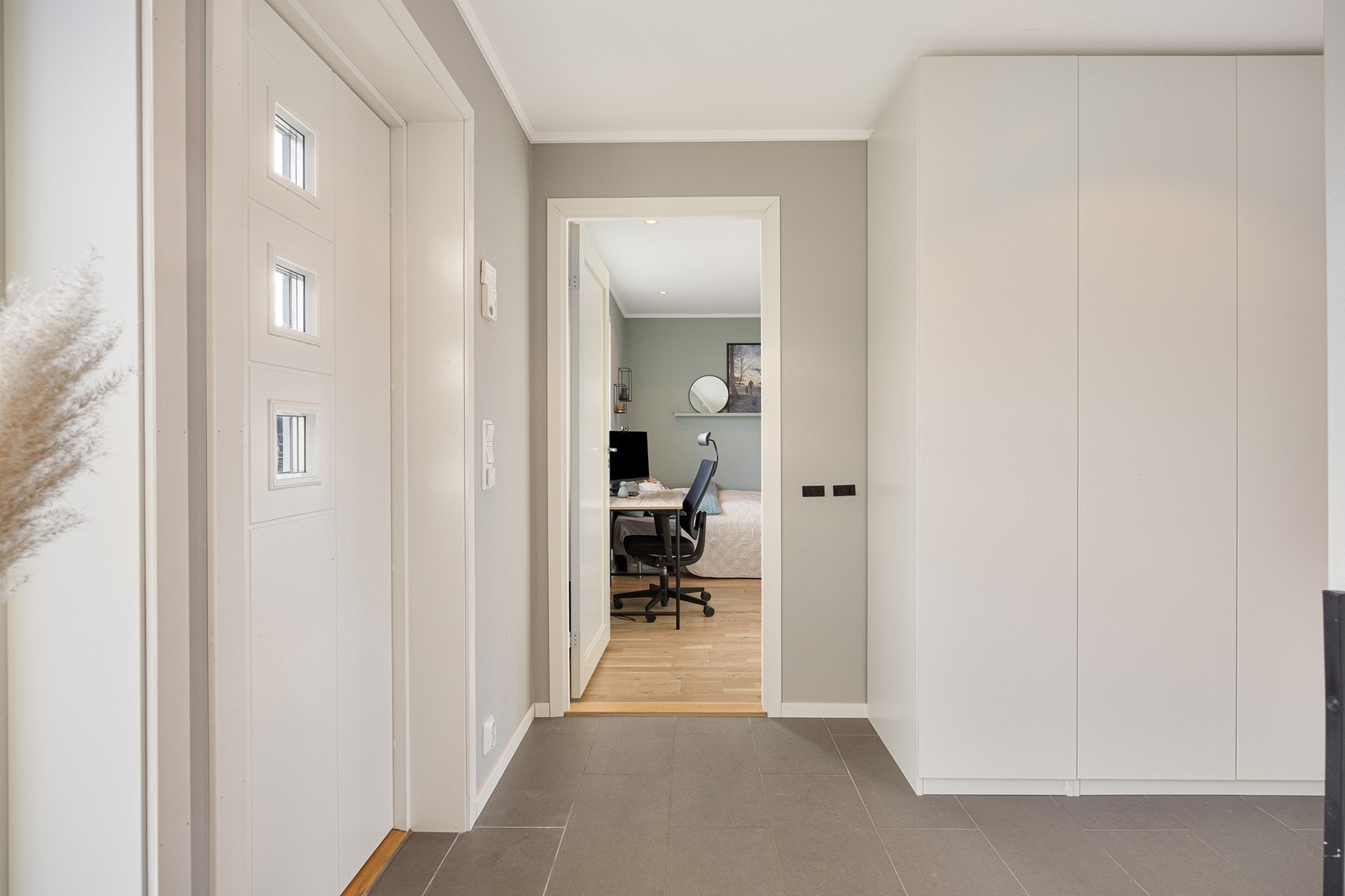 Yttertøyet ryddes enkelt bort i to store garderobeskap med hvite fronter. Galleribilde