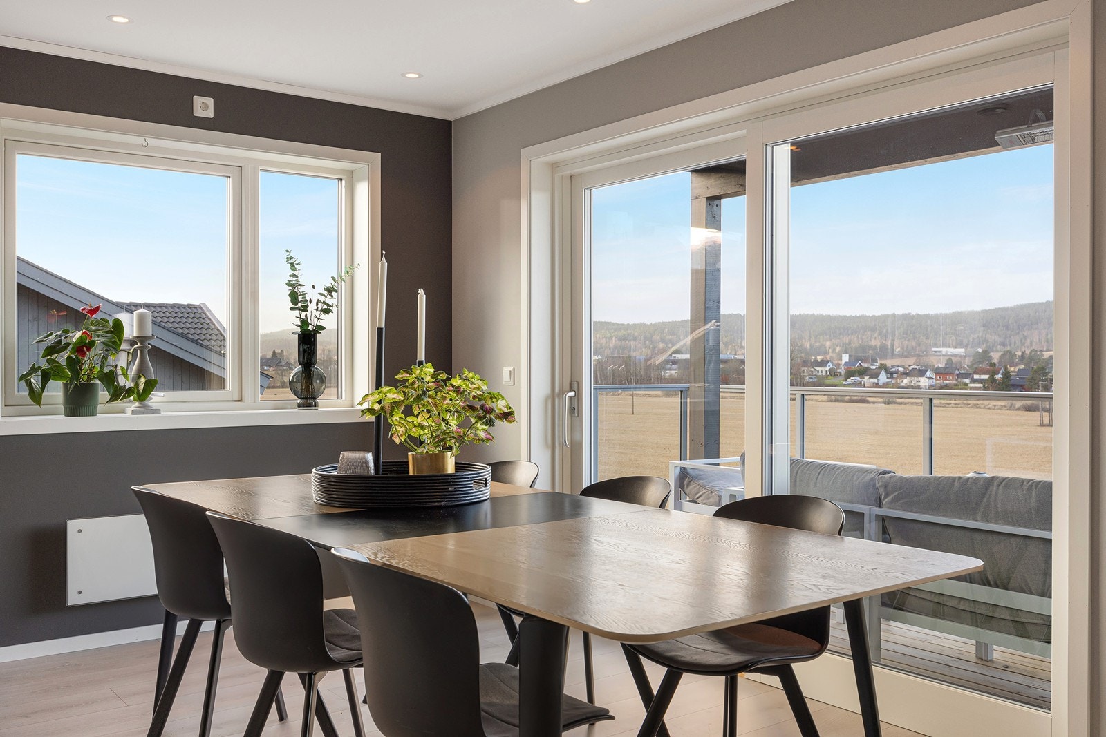 Flere vinduer går til gulvet, inkludert en skyvedør til den solfylte verandaen. Galleribilde