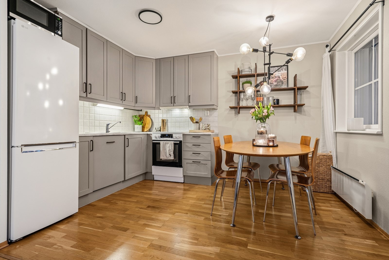 Tidløst kjøkken med grå profilerte fronter og benkeplate av typen laminat. Galleribilde