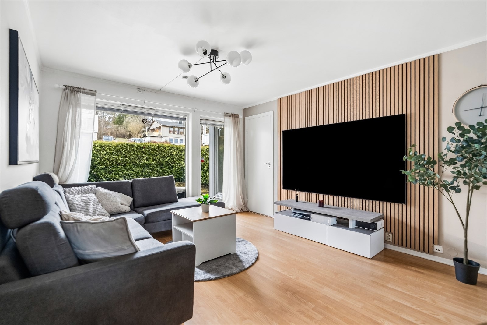 Pene flater med parkett på gulv, hvitmalte vegger og spile-kontrastvegg. Galleribilde