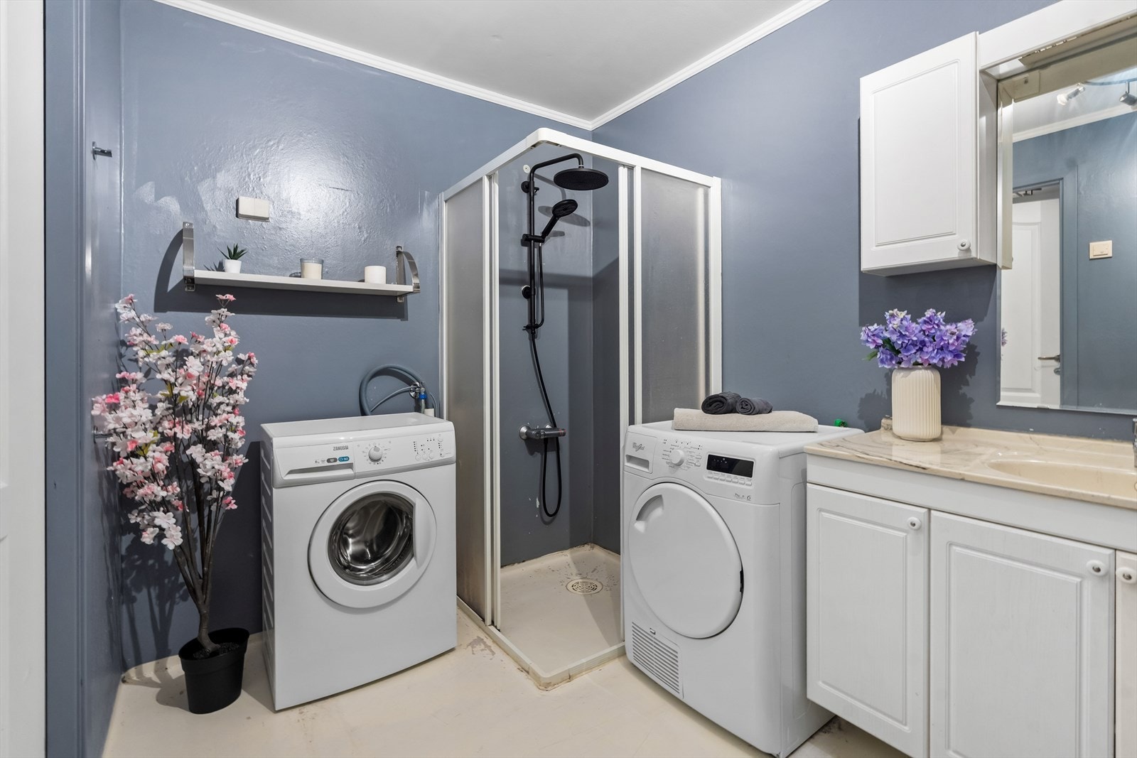 Innredet med gulvstående toalett, dusjhjørne med skyvedører og opplegg for vaskemaskin. Galleribilde