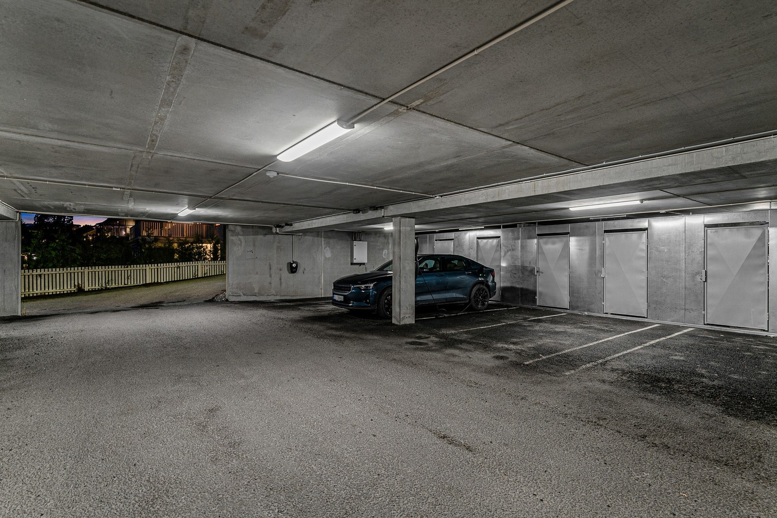 Praktisk parkeringsløsning med lader i felles garasjekjeller med enkel adkomst og tilhørende boder for ekstra oppbevaring. Galleribilde