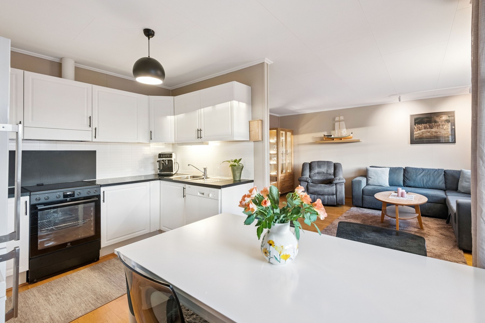 Den åpne løsningen mellom stue og kjøkken skaper en luftig atmosfære. Galleribilde