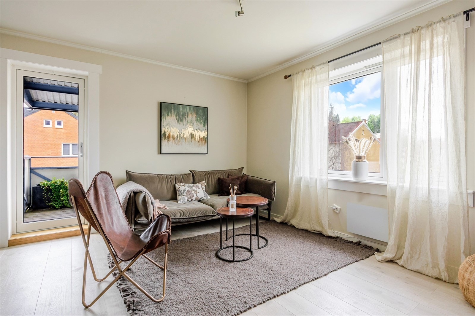 Lys og innbydende stue med gode vindusflater og utgang til balkong Galleribilde