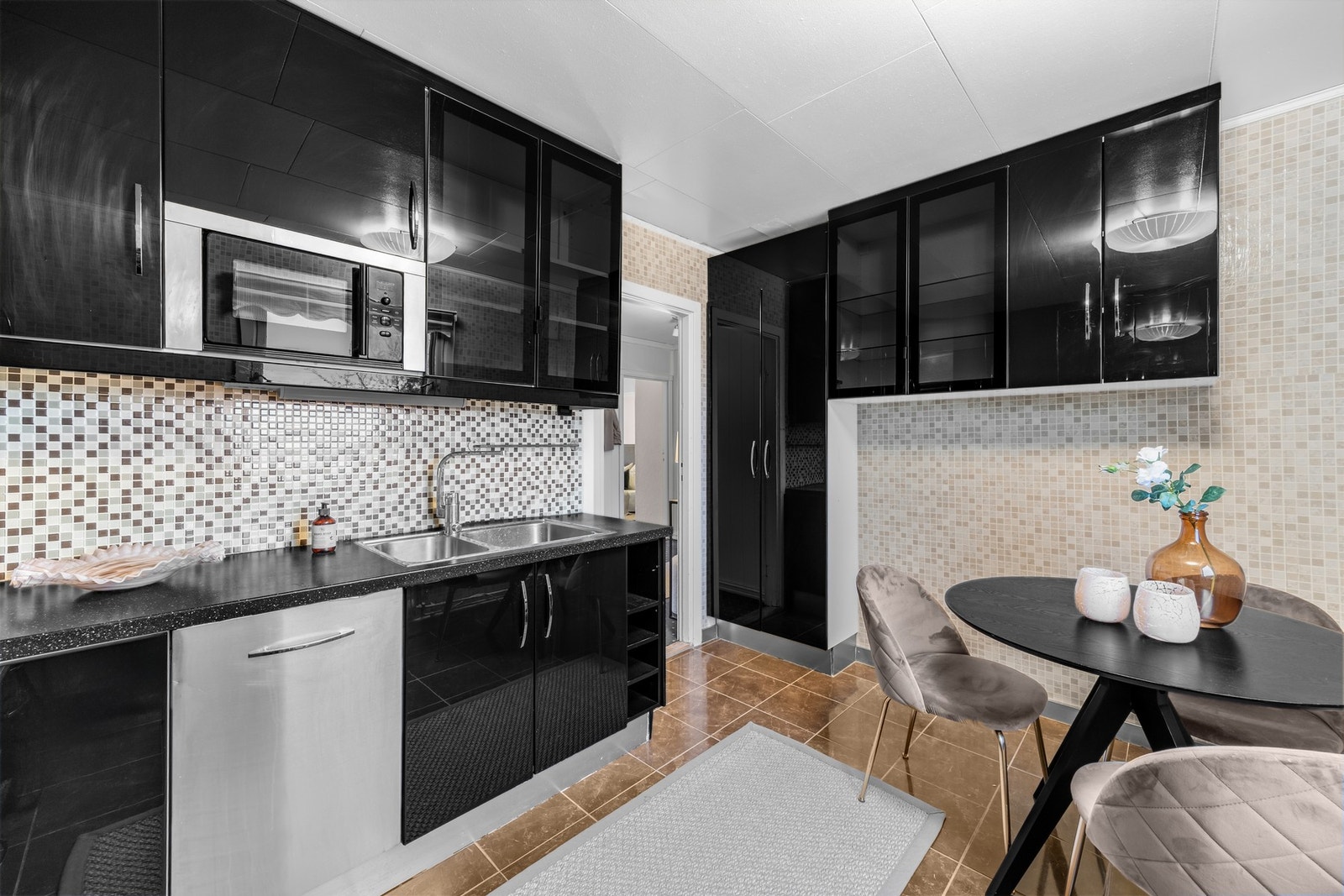 Den mørke kjøkkeninnredningen gir en fin kontrast til de lyse veggene Galleribilde