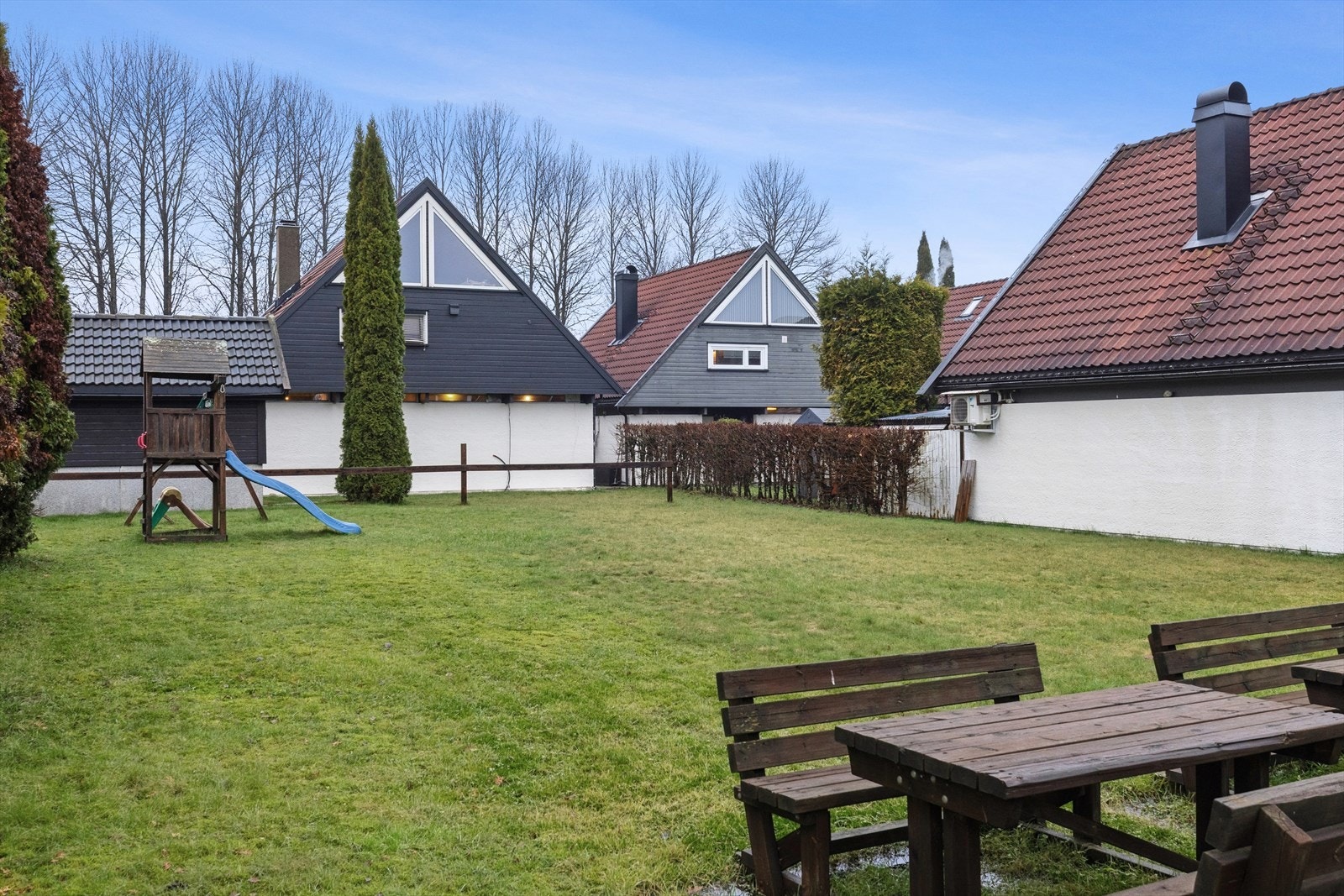 Hagen er pent opparbeidet med plen, trær og anen beplantning. Galleribilde