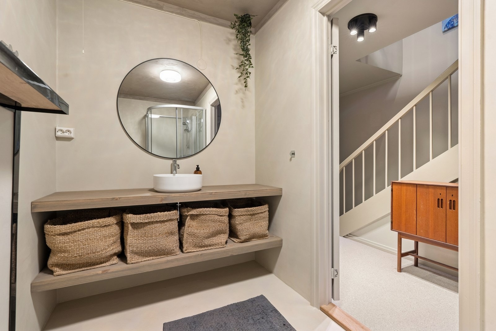 Badet er utstyrt med vegg hengt toalett, servant og dusjkabinett. Galleribilde