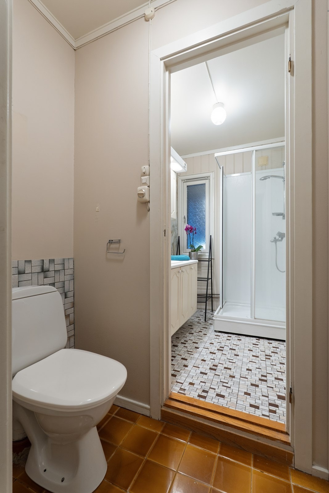 Toalettet ligger i en egen del av rommet, noe som gir ekstra skjerming og praktisk bruk. Galleribilde