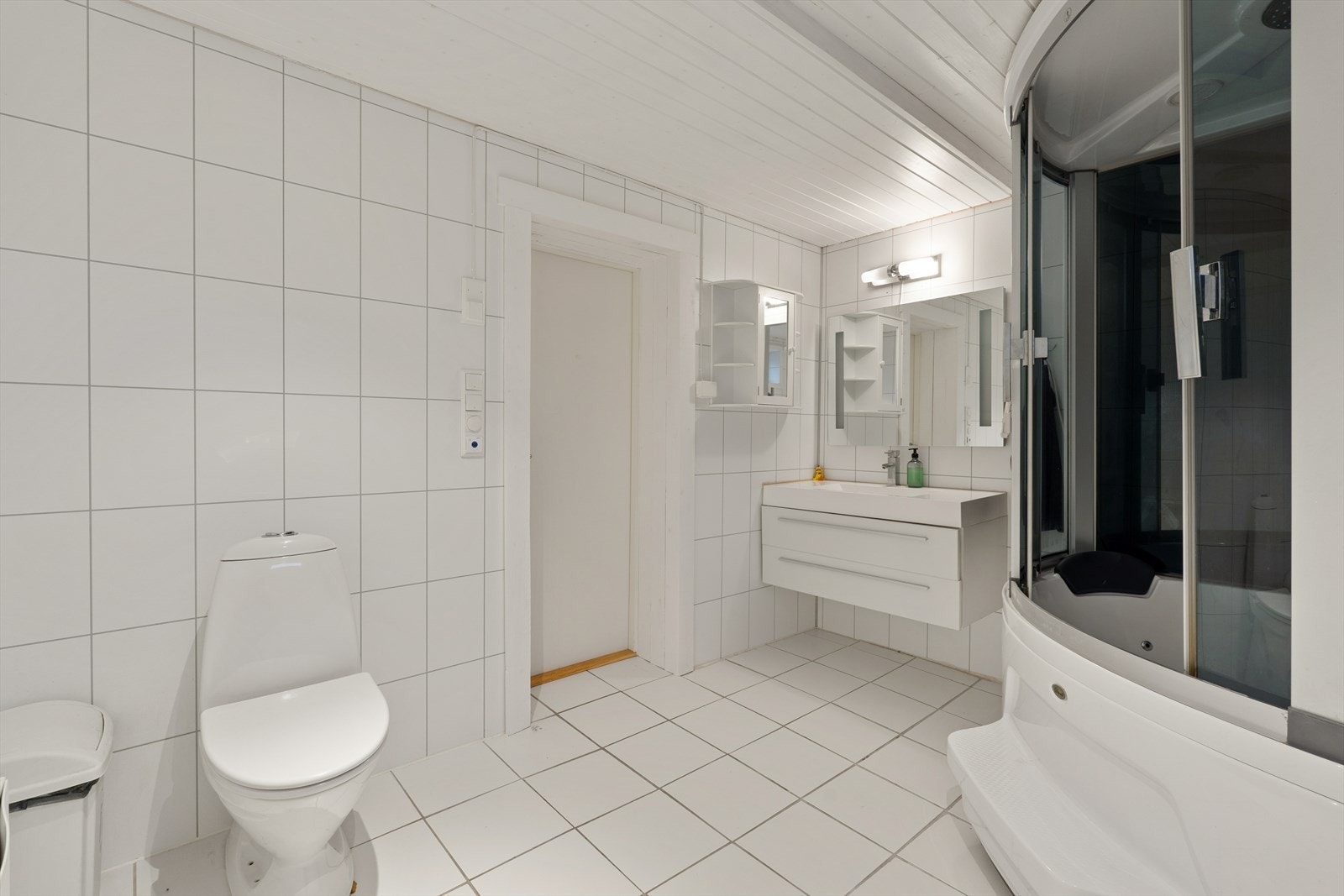 Lyst flislagt bad med gulvvarme. Badet er innredet med steamdusj, toalett og servant nedfelt i baderomsinnredning Galleribilde