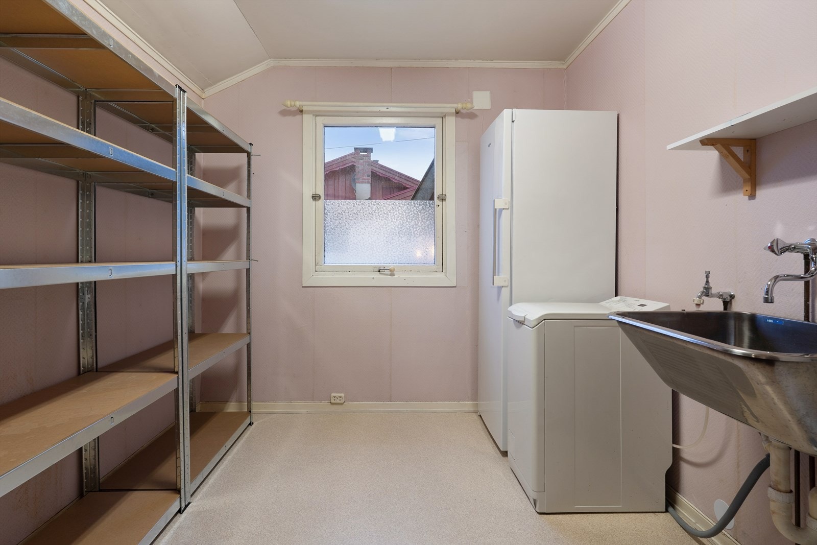 Praktisk vaskerom med montert stålvask. Rommet har plass og opplegg til vaskemaskin og byr på gode oppbevaringsmuligheter. Galleribilde