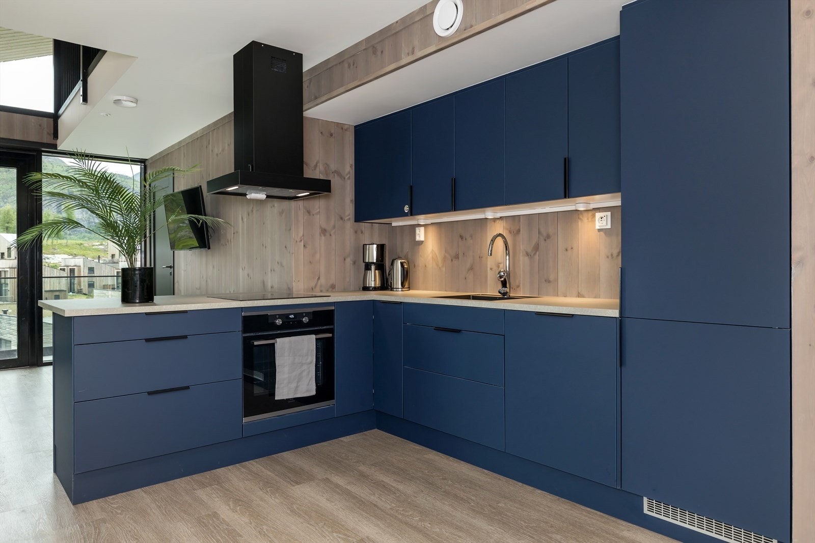 Åpen kjøkkenløsning med integrerte hvitevarer og god benk og skapplass. Galleribilde