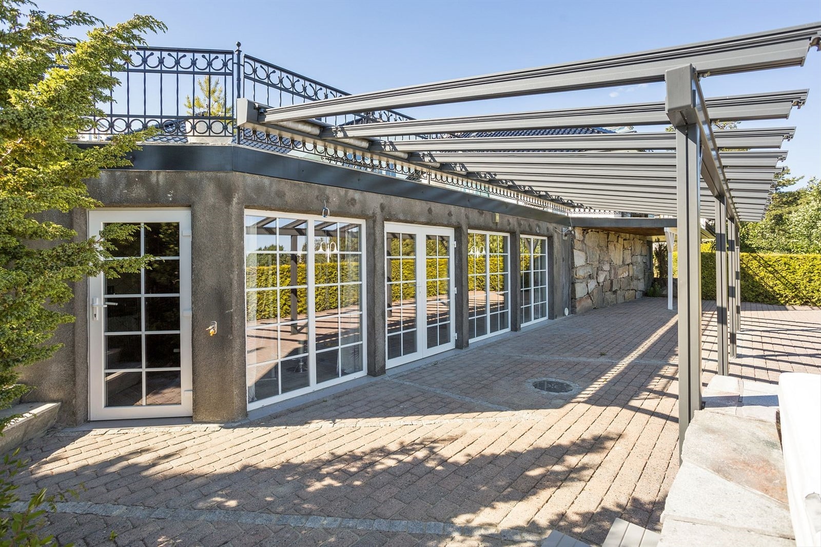 Mange nydelige uteplasser rundt eiendommen man kan forflytte seg etter vær og vind. Her er det pergola med elektrisk duk Galleribilde