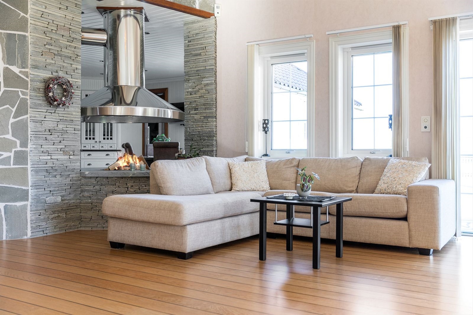 En hyggelig plass i stuen med åpen peis inn til kjøkkenet Galleribilde