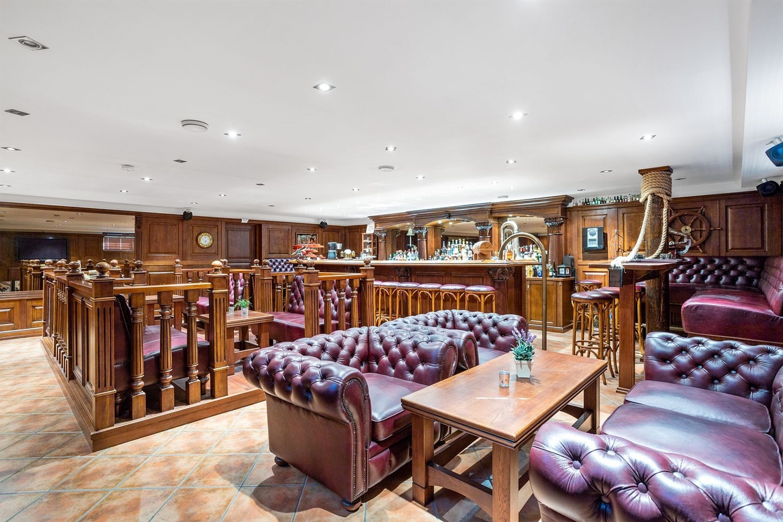 Egen stor bar innredet med massiv eik. Lekre detaljer med håndskjærede innredninger. Chesterfield møbler, vinskap, isbitmaskin, vegghengt Tv, og høyttalere rundt i hele rommet er noe av denne avdelingen har å by på. Galleribilde