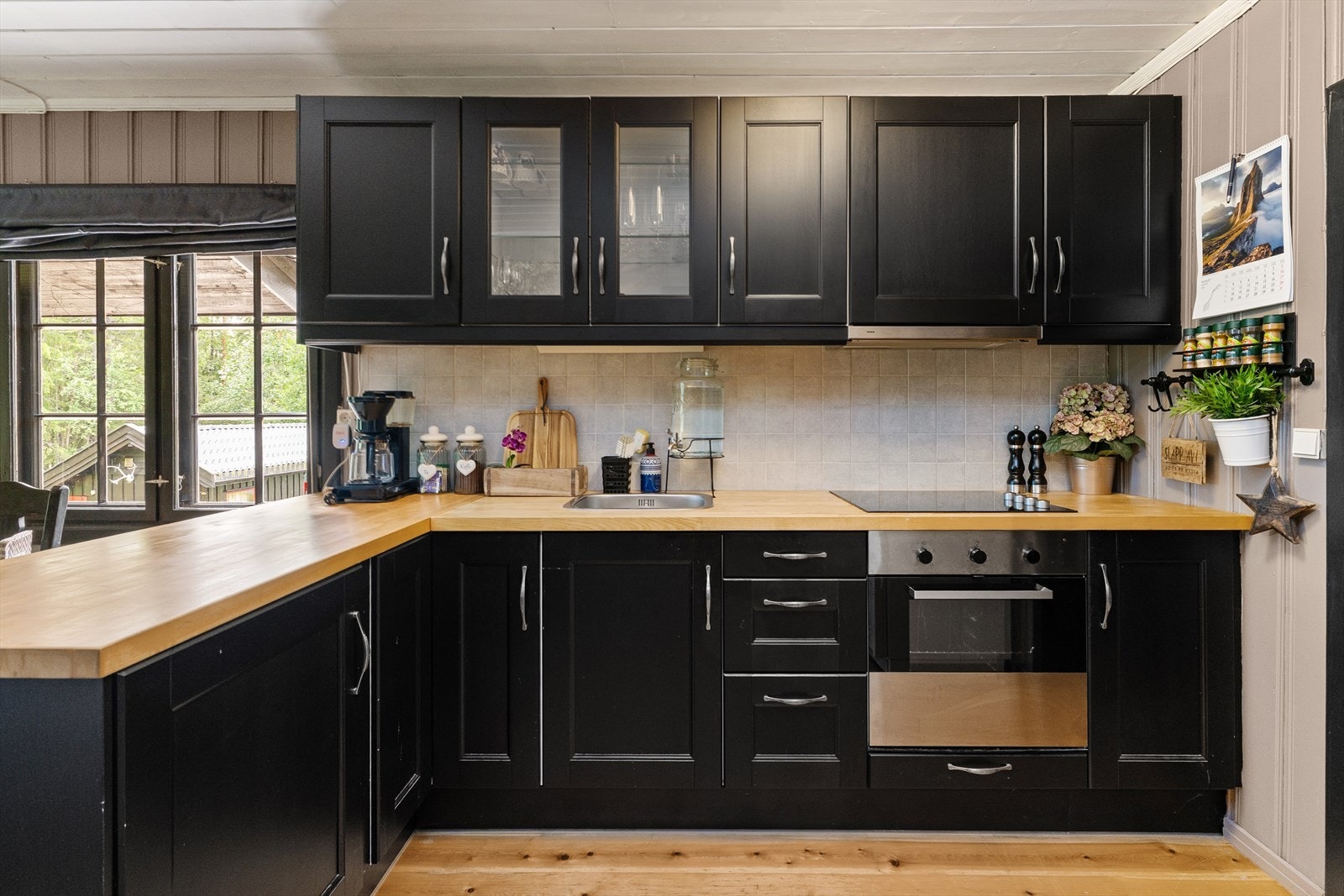 Kjøkkenet har innredning med profilerte fronter. Benkeplaten er av heltre. Det er frittstående kjøleskap, platetopp og stekeovn Galleribilde