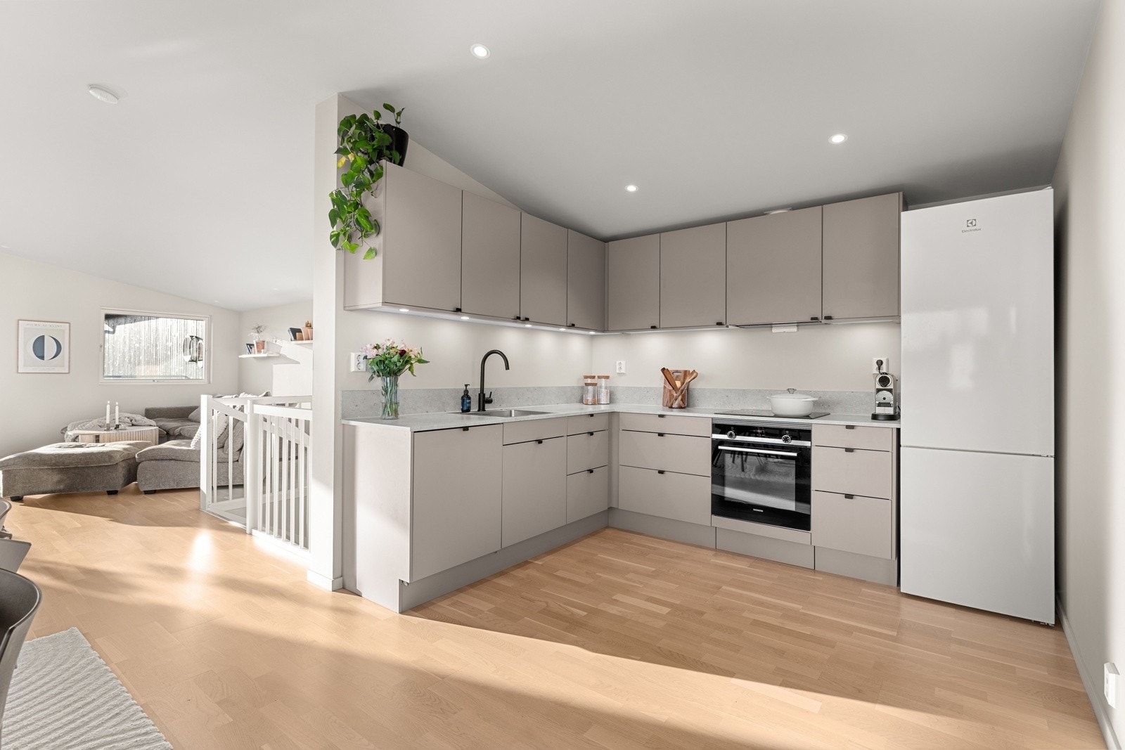 Kjøkkenet fra Sigdal fremstår stilrent og praktisk med glatte fronter og en robust laminert benkeplate. Galleribilde