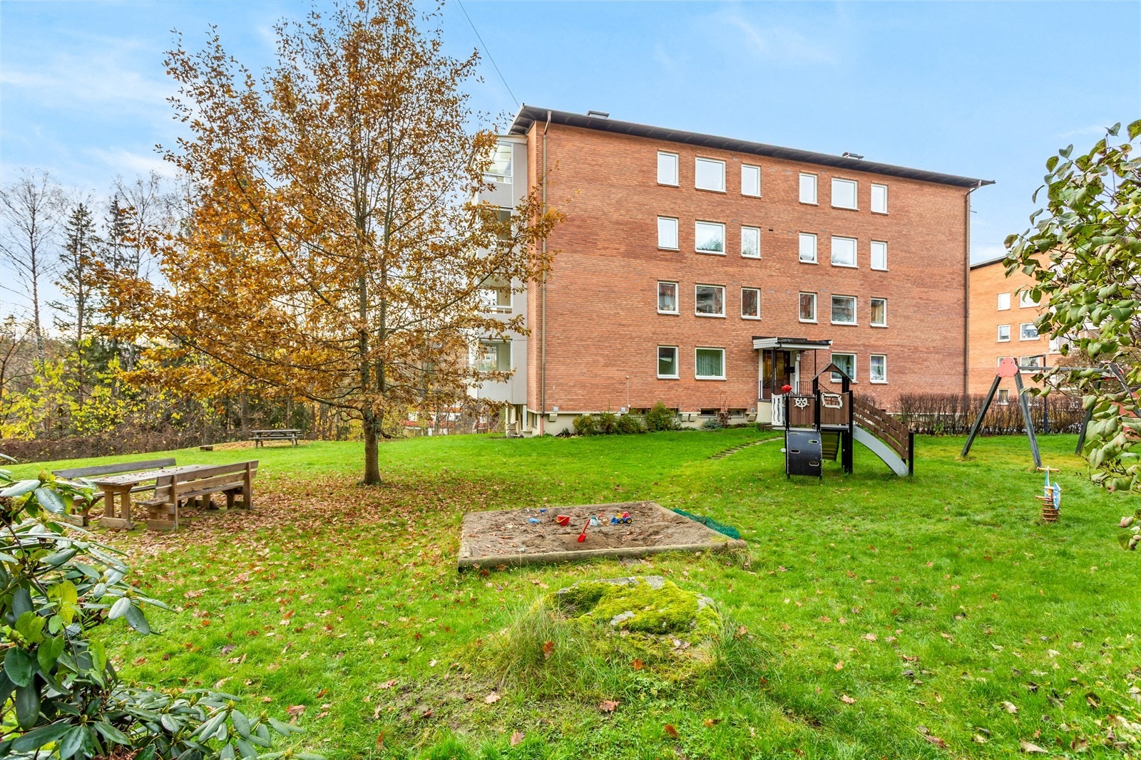 Eiendommen er pent opparbeidet med asfalterte internveier, gressplener, variert beplantning, lekeplasser og sittegrupper Galleribilde