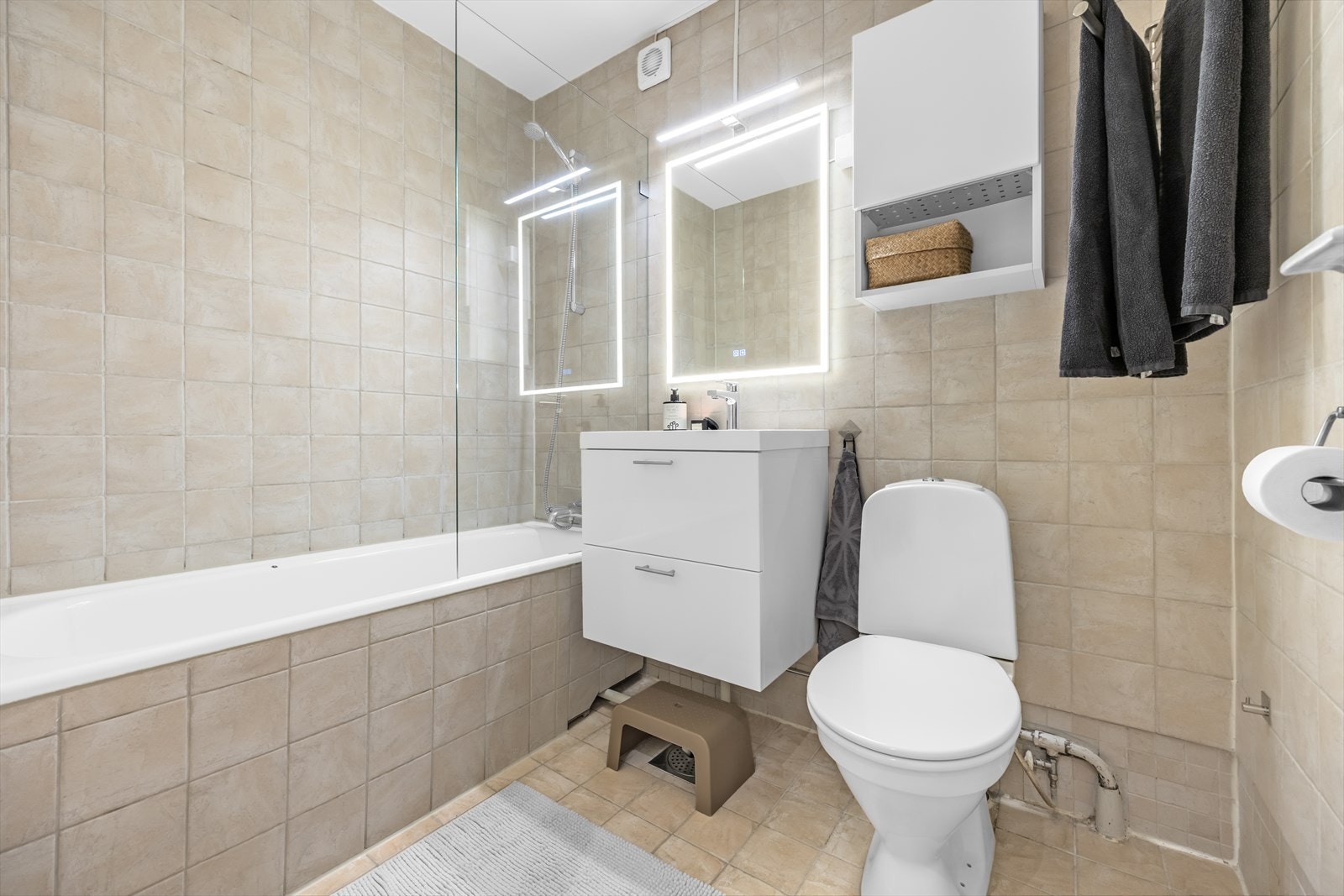 Badet er praktisk plassert ved entreen og byr på flislagte vegger og gulv med varmekabler. Galleribilde