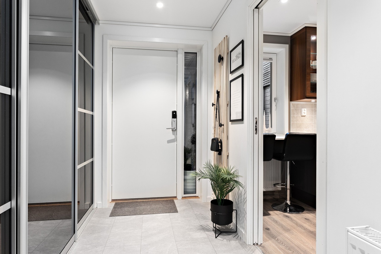 Innbydende entré som måler 6,5 kvadratmeter med skyvedørsgarderobe for praktisk oppheng av ytterklær. Galleribilde