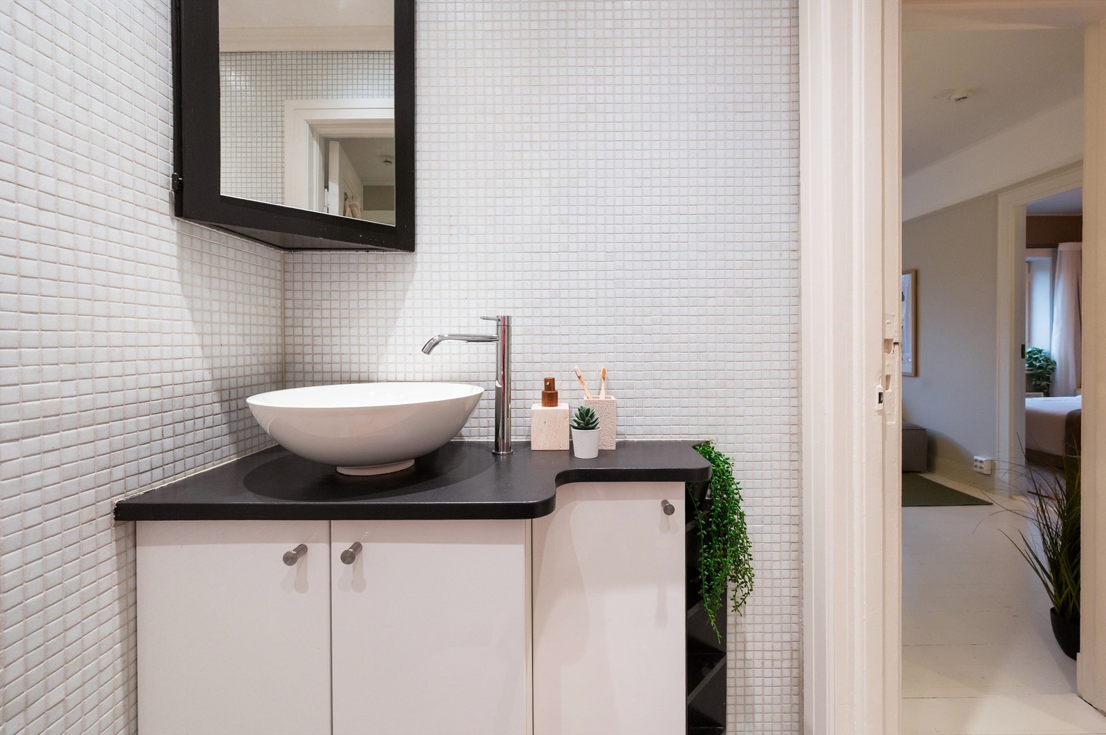 Moderne innredning med både plassbygd hylle ved toalett og et plassbygd speilskap over servant Galleribilde